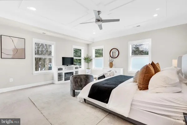 a spacious bedroom with a bed a chandelier and a couch