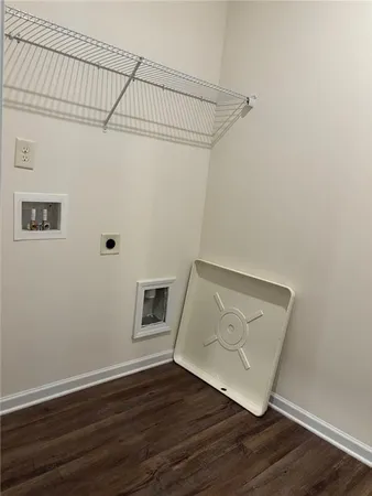a view of an empty room with wooden floor and a ceiling fan