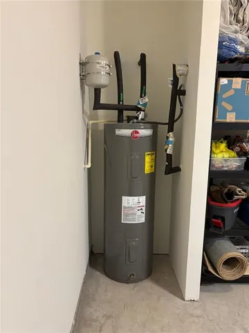 a view of a backyard with plants and large trees with wooden fence