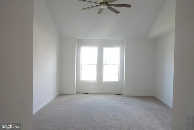 an empty room with a window and a fan
