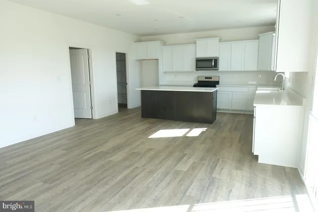 a kitchen with granite countertop a stove a sink and a refrigerator