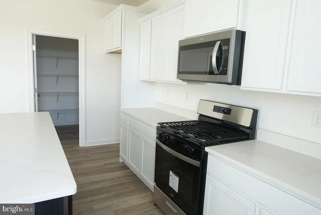 a kitchen with stainless steel appliances a stove microwave and sink
