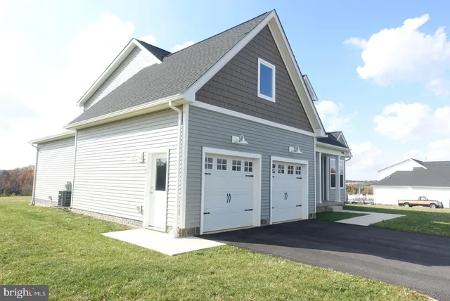 a view of a big house with a big yard and a large tree