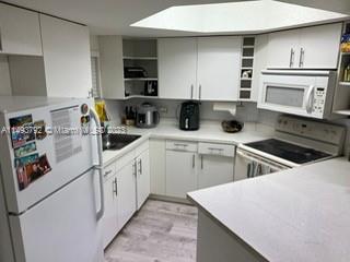 a kitchen with cabinets and white appliances