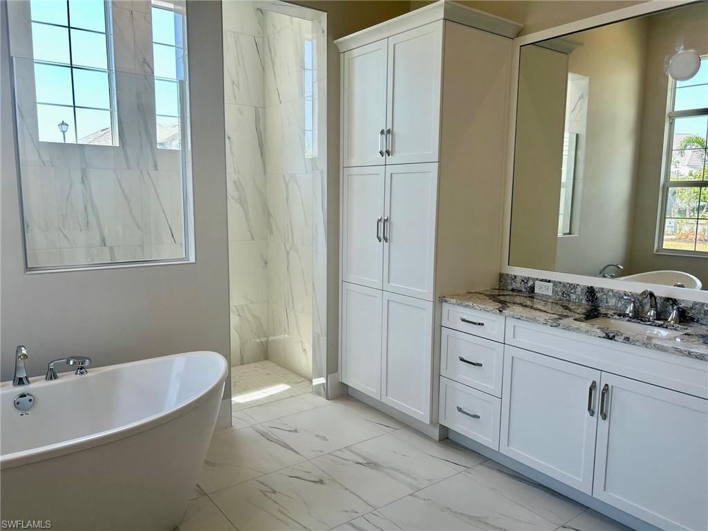 8892 Nevis Way Naples, FL 34113 - Photo 3 of 5 a bathroom with a tub sink and mirror