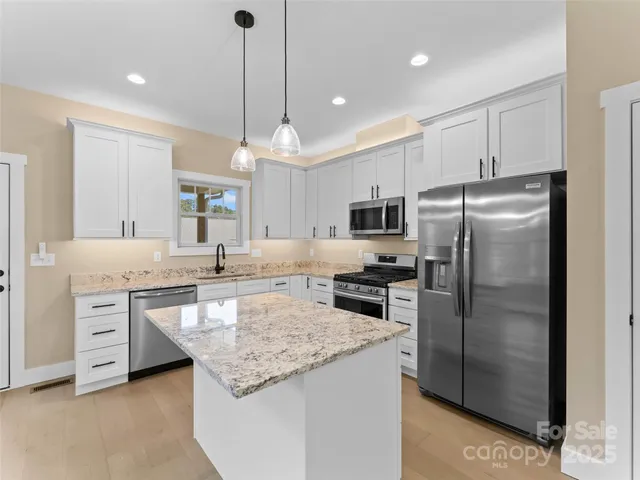 a kitchen with a refrigerator a sink and cabinets