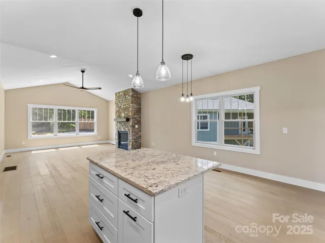 a kitchen with a stove kitchen island and windows