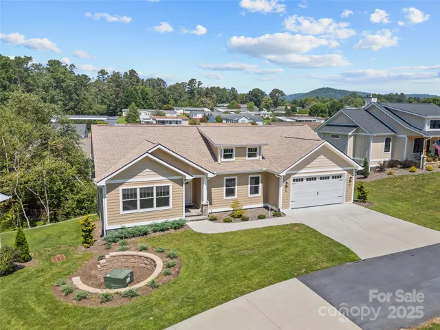 an aerial view of a house with swimming pool and a yard