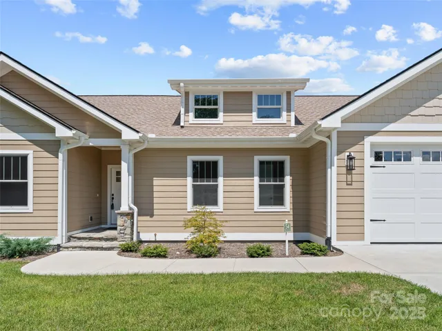 a front view of a house with a garden and plants