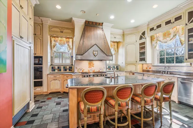 a kitchen with stainless steel appliances granite countertop a stove a sink and a dining table
