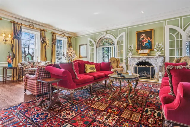 a living room with furniture a fireplace and a floor to ceiling window