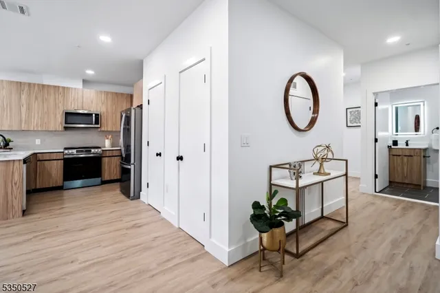 a living room with kitchen island furniture a chandelier a stove and kitchen view