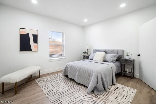 a spacious bedroom with a bed and wooden floor