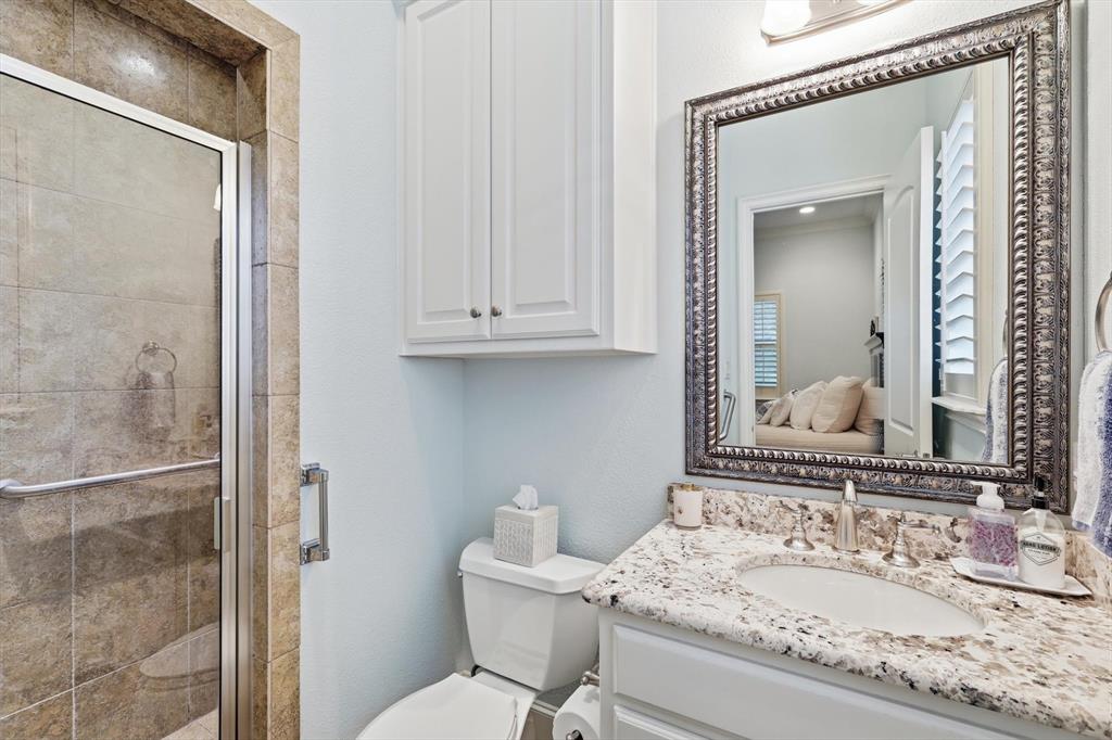 476 Hidden Valley Lane Coppell, TX 75019 - Photo 31 of 40 a bathroom with a granite countertop sink a toilet and shower