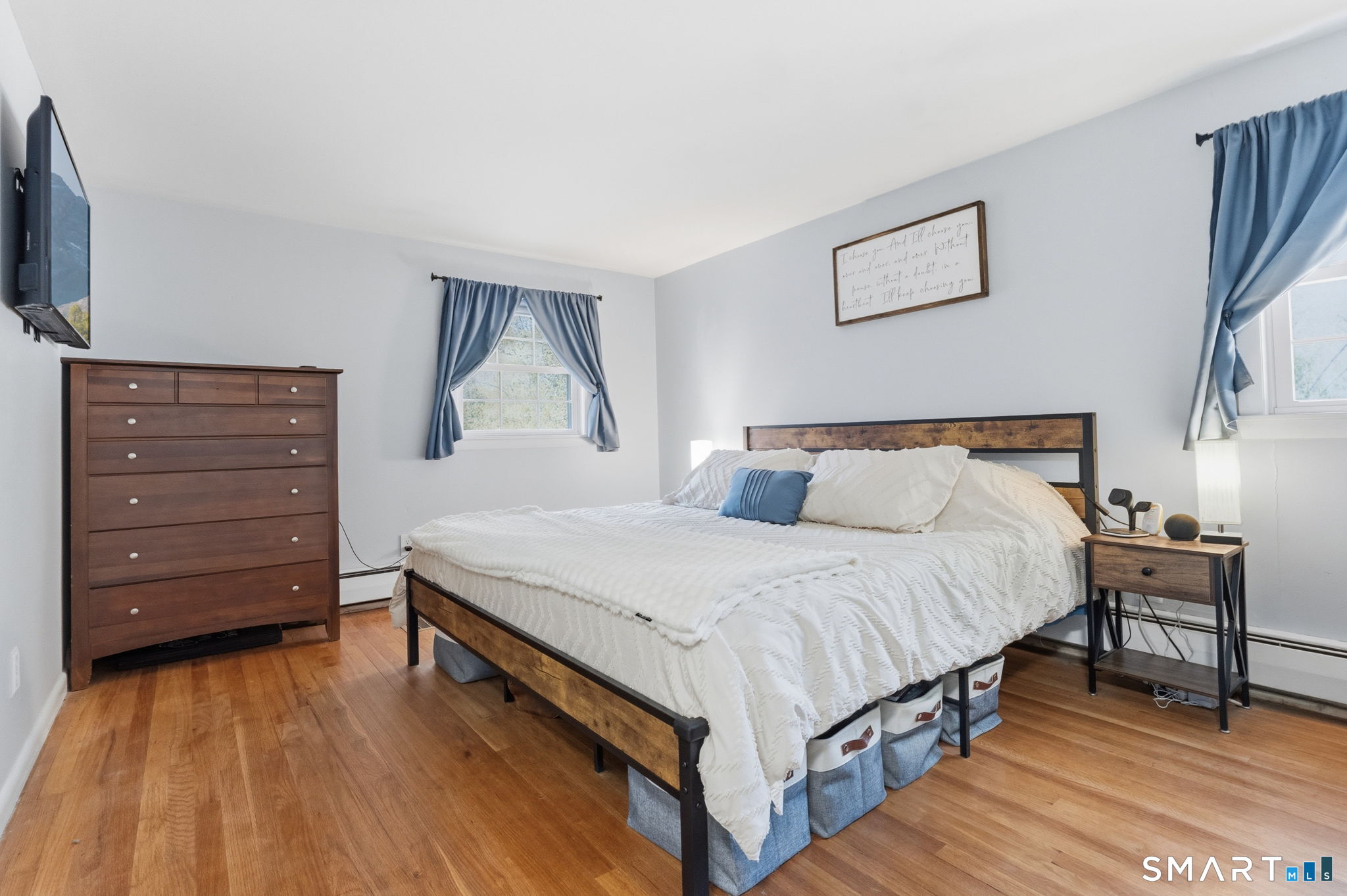523 Essex Road Westbrook, CT 06498 - Photo 13 of 37 a bedroom with a bed a mirror on dresser and a wooden floor