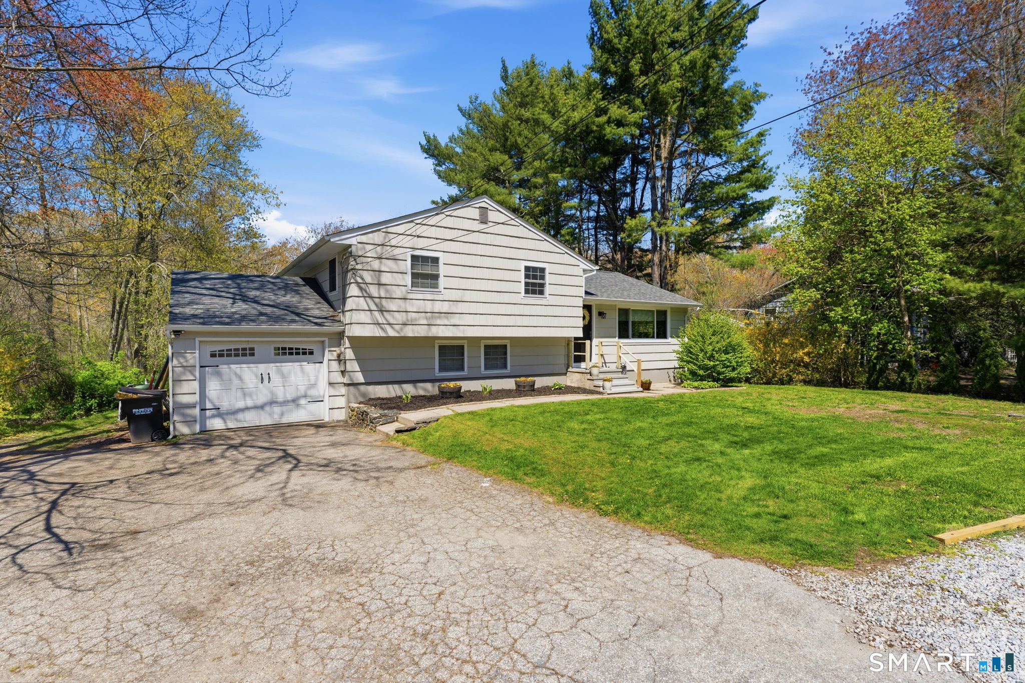 523 Essex Road Westbrook, CT 06498 - Photo 3 of 37 a front view of a house with a garden and trees