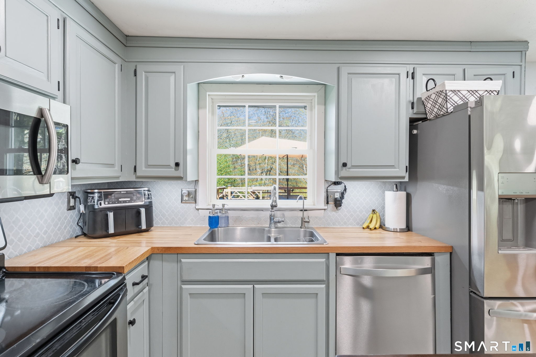 523 Essex Road Westbrook, CT 06498 - Photo 10 of 37 a kitchen with stainless steel appliances a sink cabinets and a window