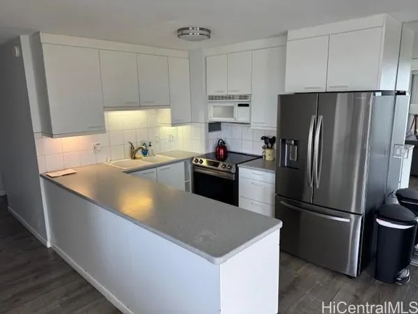 a kitchen with stainless steel appliances granite countertop a refrigerator a sink a stove a microwave and island