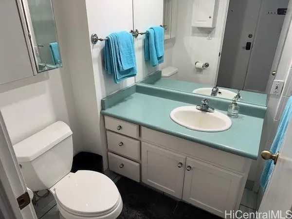 a bathroom with a toilet sink and mirror