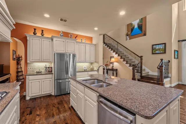a kitchen with stainless steel appliances granite countertop a sink refrigerator and microwave