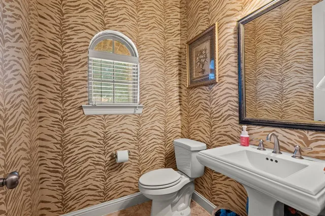 a bathroom with a sink a toilet and mirror