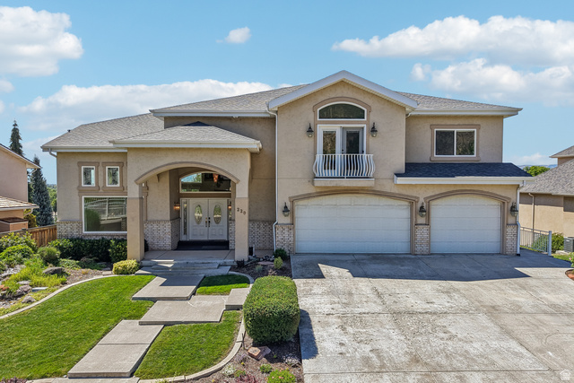 220 East Ridge Road Orem, UT 84057 - Photo 1 of 52 Stucco exterior with a balcony, arched entry, double front doors, and a two-car garage