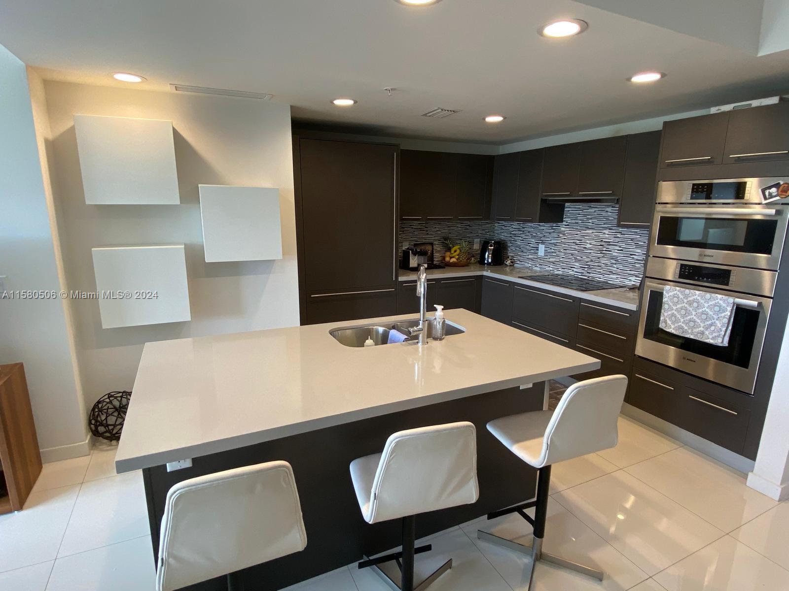 a kitchen with a table chairs stove and kitchen island