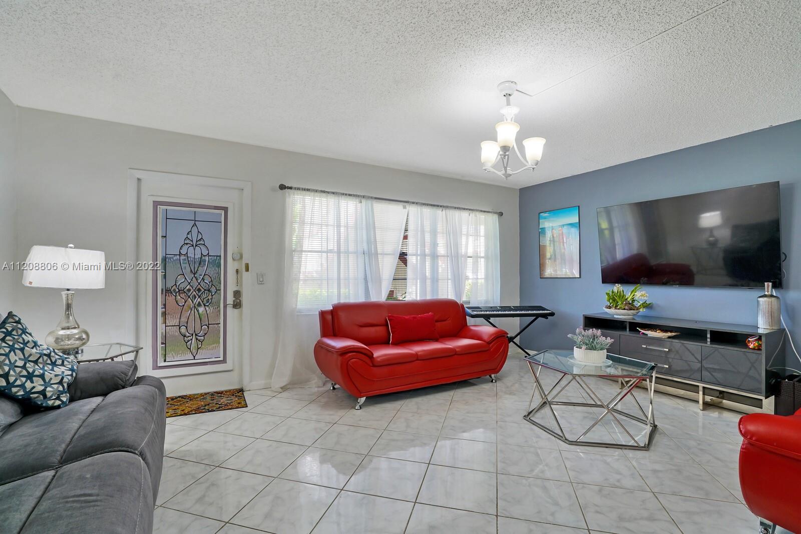 181 Fanshaw East, Unit 181 Boca Raton, FL 33434 - Photo 3 of 25 a living room with furniture and a flat screen tv