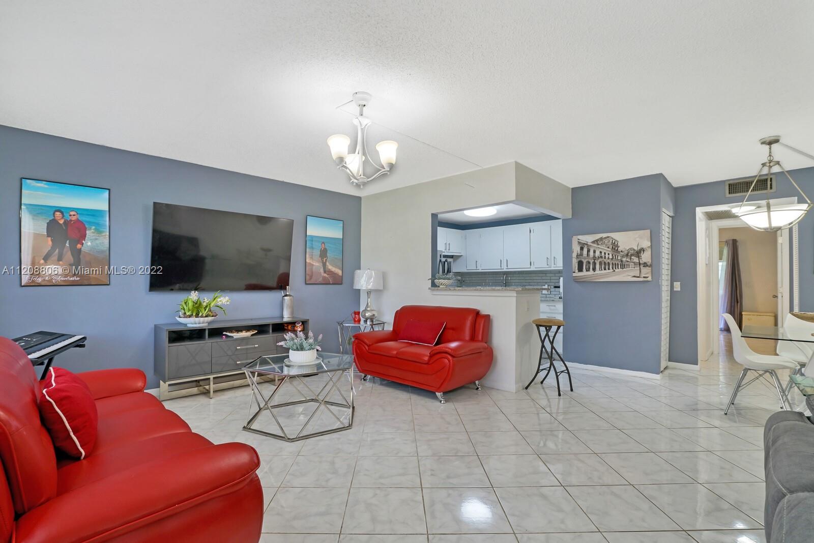 181 Fanshaw East, Unit 181 Boca Raton, FL 33434 - Photo 5 of 25 a living room with furniture and a flat screen tv