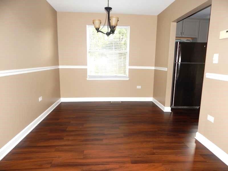 1216 Calico Avenue Naperville, IL 60564 - Photo 3 of 16 a view of an empty room with wooden floor and a window