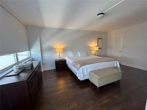 a large bed sitting in a bedroom next to a window