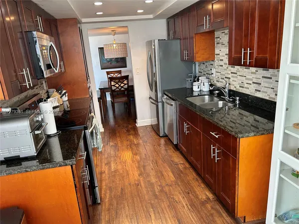a bathroom with a granite countertop toilet sink and mirror