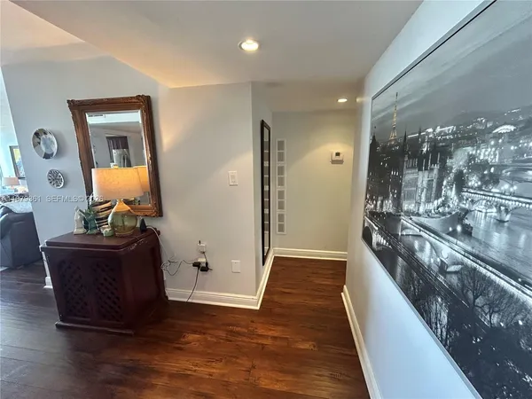 a view of a hallway with wooden floor and stairs
