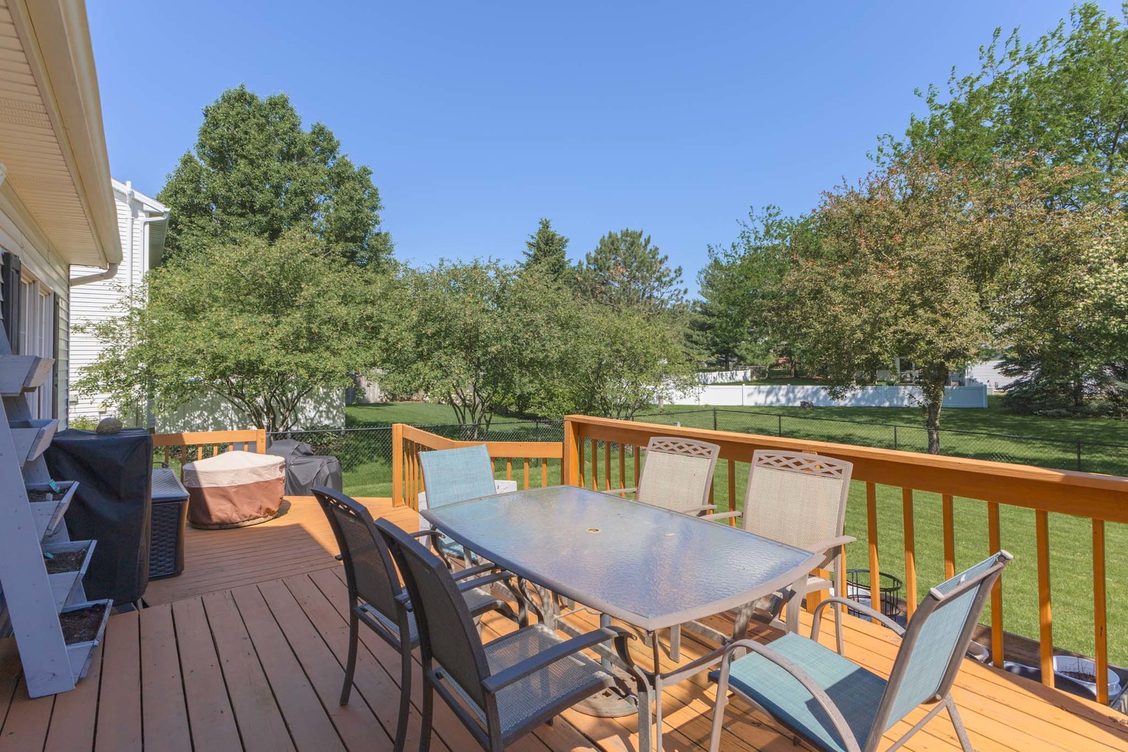 3308 Cumbria Drive Bloomington, IL 61704 - Photo 4 of 48 a balcony of a house with wooden floor outdoor seating and trees in the background