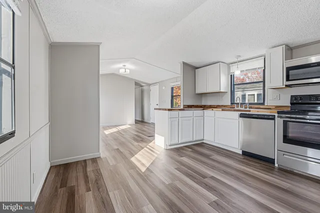 a kitchen with cabinets oven and a sink