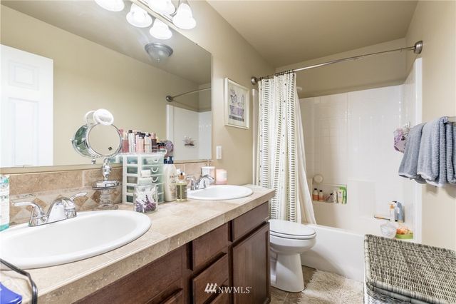 a bathroom with a double vanity sink toilet and shower