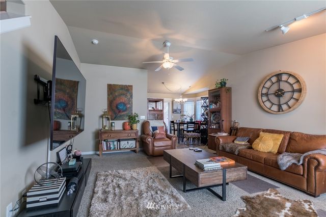 a living room with furniture a flat screen tv and a wall painting