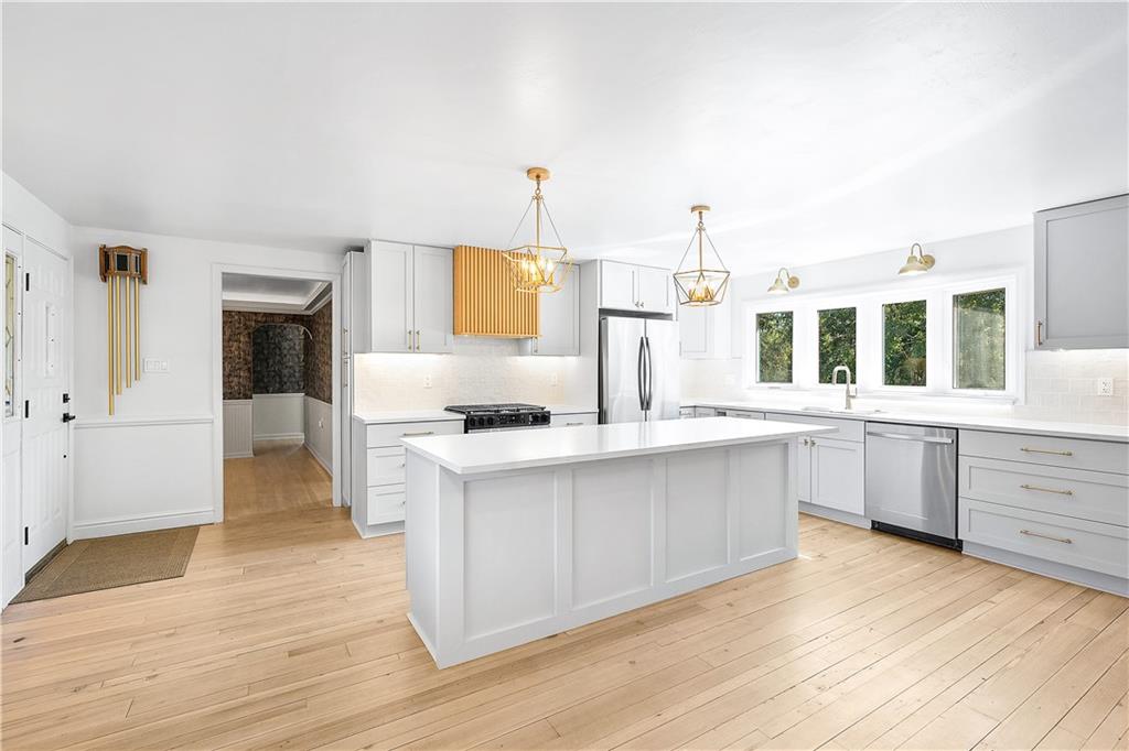 115 Elm Lane Coraopolis, PA 15108 - Photo 11 of 50 a large white kitchen with wooden floor and stainless steel appliances