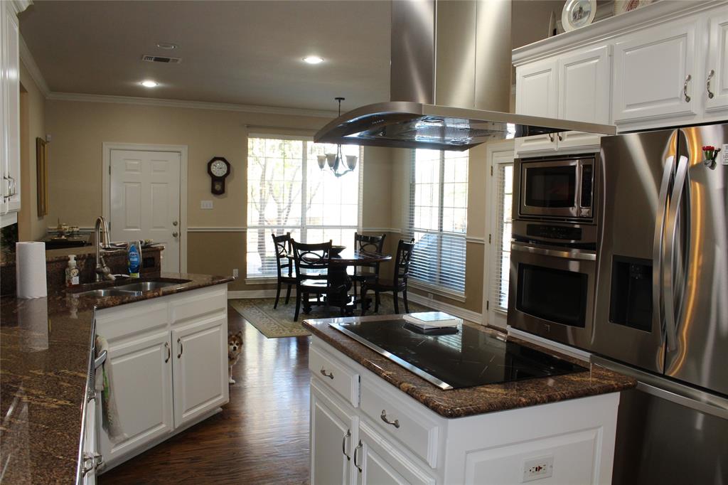 2131 Deer Run Denison, TX 75020 - Photo 23 of 35 a kitchen with stainless steel appliances granite countertop a sink a stove and a refrigerator