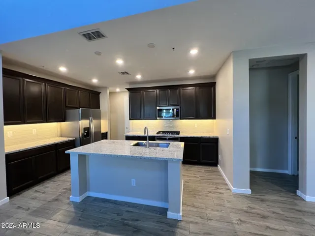 a large kitchen with stainless steel appliances a large counter top