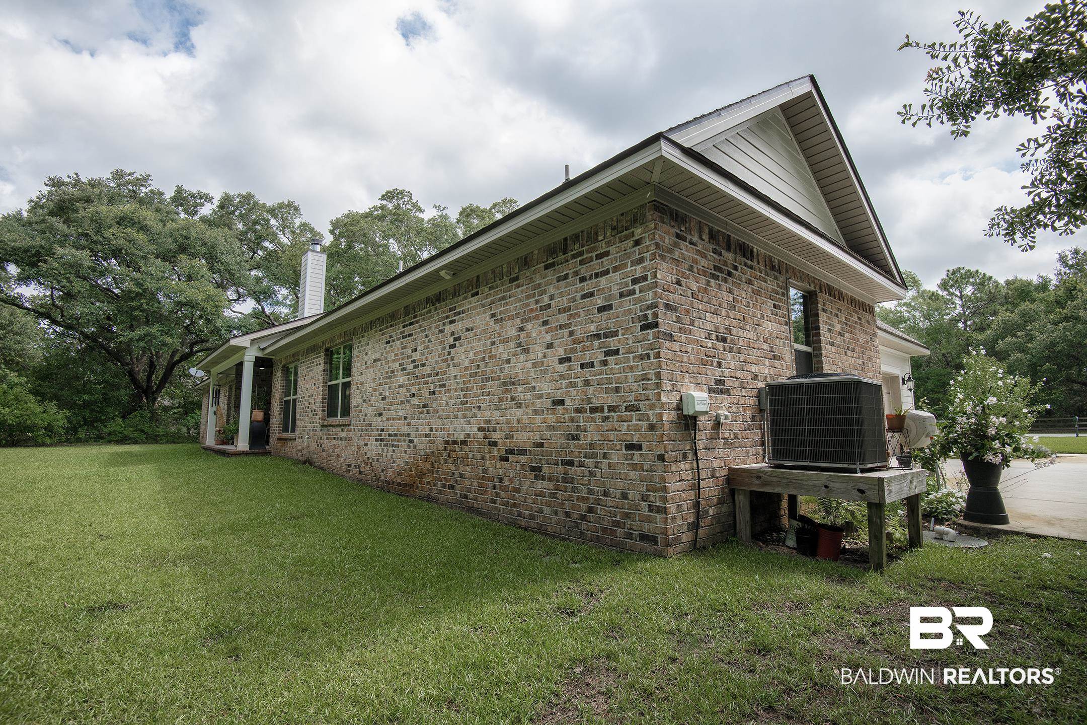 18754 Treasure Oaks Road Gulf Shores, AL 36542 - Photo 42 of 53 Brick exterior with a gabled roof and white trim