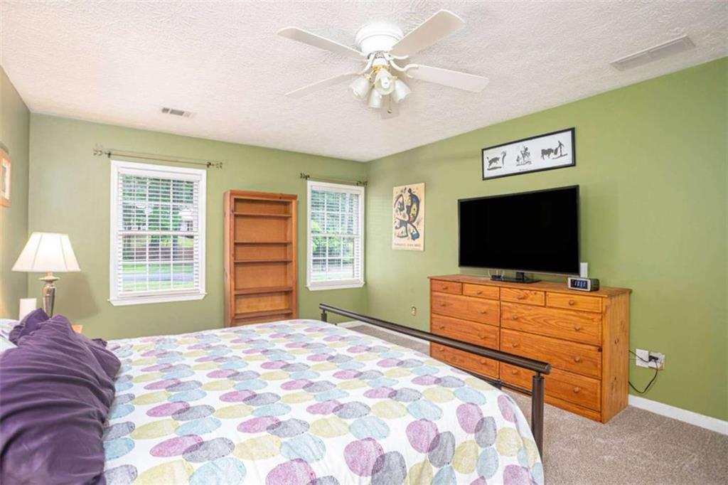 3838 Hunting Ridge Drive Southwest Lilburn, GA 30047 - Photo 27 of 56 a bedroom with a bed and a flat screen tv