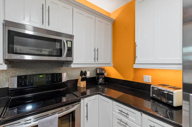 a living room with furniture a fireplace and a floor to ceiling window