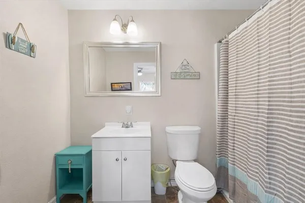 a bathroom with a toilet a sink and mirror