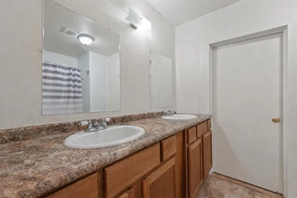 a bathroom with a granite countertop sink and a mirror
