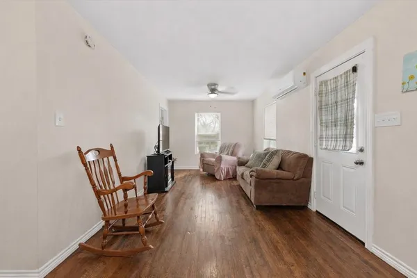 a living room with furniture and a wooden floor