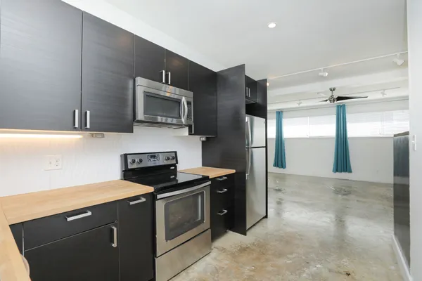 a kitchen with stainless steel appliances granite countertop a refrigerator and a stove top oven