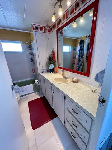a spacious bathroom with a granite countertop sink a mirror and shower