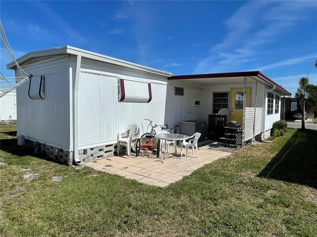 a view of a house with backyard and sitting area