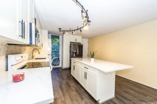 a large white kitchen with a stove and a sink